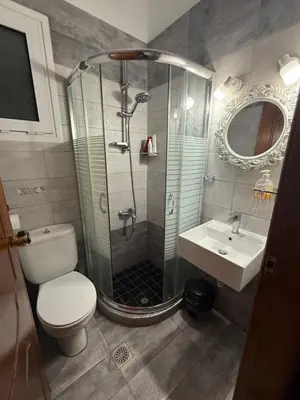 a bathroom with a shower and a toilet and a sink at Modern 1-bedroom with BBQ & Roof Garden near Beach in Stalos