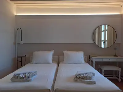two beds in a room with a mirror at Hotel Amphora in Chania Town