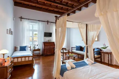 a bedroom with two beds and a living room at Hotel Amphora in Chania Town