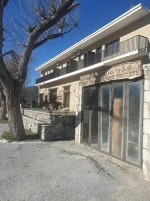a building with a sign on the front of it at To Ellinikon in Omalós
