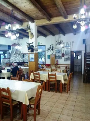 a restaurant with tables and chairs in a room at To Ellinikon in Omalós