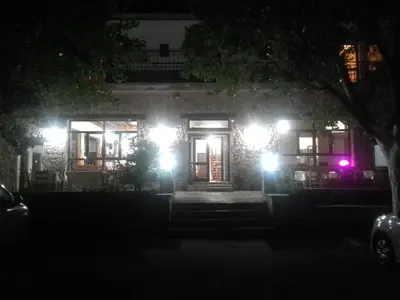 a house with lights on the front of it at night at To Ellinikon in Omalós