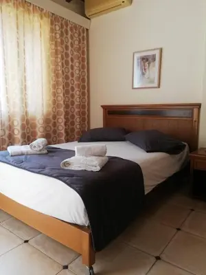 a bedroom with two beds and a window at Toxo Hotel in Plataniás