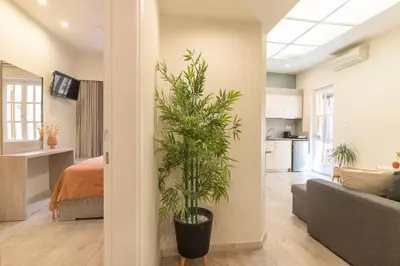 a living room with a couch and a plant at Lidra Rooms in Chania Town