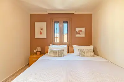 a bedroom with a large white bed with two pillows at Lidra Rooms in Chania Town
