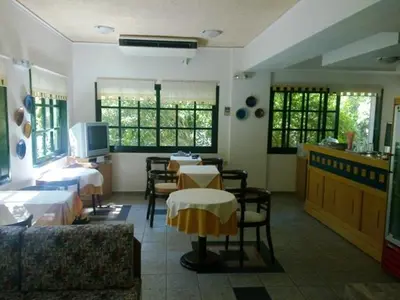 a restaurant with tables and chairs in a room at Rea Hotel in Palaiochóra