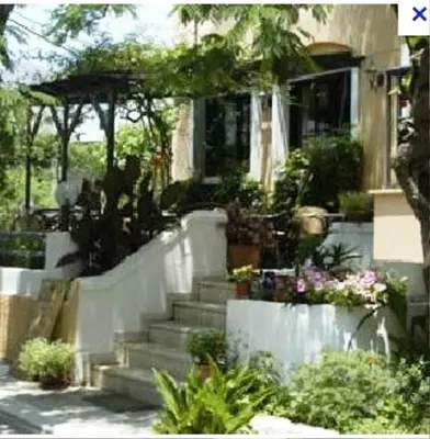 a house with stairs and plants in front of it at Rea Hotel in Palaiochóra