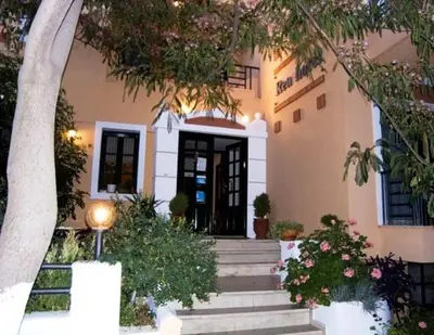 a house with stairs leading up to a door at Rea Hotel in Palaiochóra