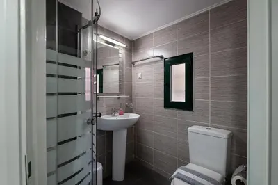 a bathroom with a white toilet and a sink at Anastasia Apartments in Chania Town