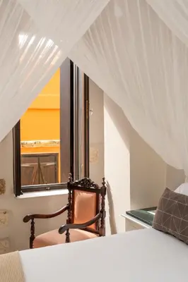 a bedroom with a chair and a window at Santa Elena Boutique Rooms in Chania Town