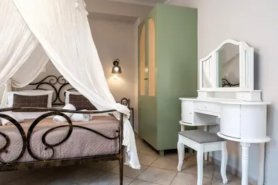 a bedroom with a bed and a vanity and a mirror at Santa Elena Boutique Rooms in Chania Town