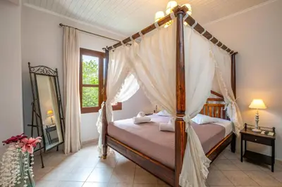 a bedroom with a canopy bed and a mirror at Santa Elena Boutique Rooms in Chania Town