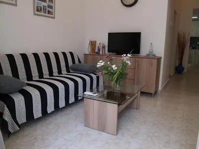 a living room with a couch and a table with flowers at Brigitte house in Chania Town