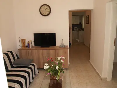 a living room with a couch and a clock on the wall at Brigitte house in Chania Town