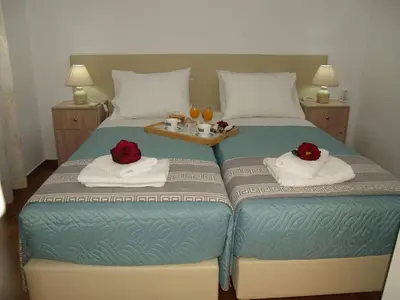 a bed with two red roses on top of it at Brigitte house in Chania Town