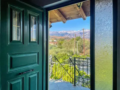 a green door with a view of the mountains at Kavros House in Arménoi