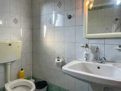 a bathroom with a sink and a toilet and a mirror at Kavros House in Arménoi