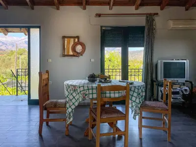 a dining room with a table and chairs and a television at Kavros House in Arménoi