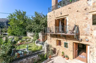 an external view of a stone building with a balcony at Ifigenia Theriso Village in Thérison