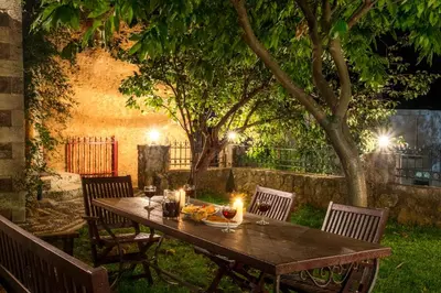 a wooden table in a yard with candles on it at Ifigenia Theriso Village in Thérison