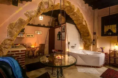 a bathroom with a tub and a glass table at Ifigenia Traditional Rooms & Maisonettes in Chania Town