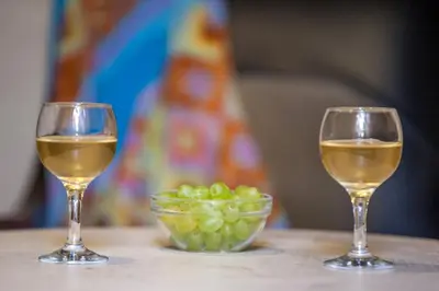 two glasses of white wine and a bowl of green grapes at Ifigenia Traditional Rooms & Maisonettes in Chania Town