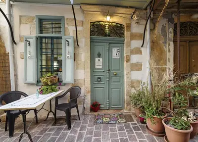 a table and chairs in front of a green door at Pension Lena in Chania Town