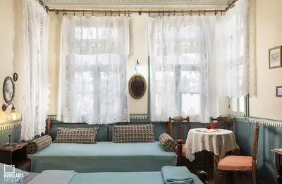 a living room with a couch and two windows at Pension Lena in Chania Town