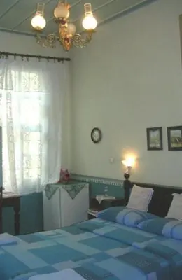 a bedroom with a blue bed and a window at Pension Lena in Chania Town