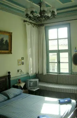a bedroom with a bed and a window and a tv at Pension Lena in Chania Town
