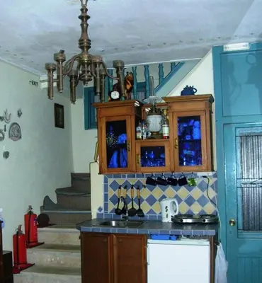 a kitchen with a chandelier and a staircase at Pension Lena in Chania Town