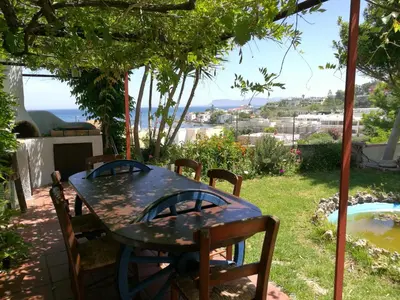 a table and chairs in a yard with a view at Chania Sea View Summer House in Kalamaki Chanion