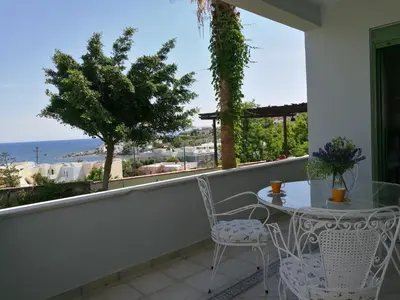 a balcony with a table and chairs and a view of the ocean at Chania Sea View Summer House in Kalamaki Chanion