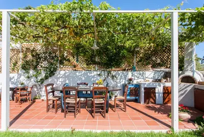 a patio with a table and chairs under a tree at Chania Sea View Summer House in Kalamaki Chanion