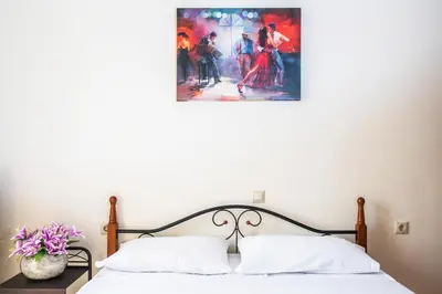 a bedroom with a bed with a painting on the wall at Marelen Apartment Near Chania Center in Chania Town