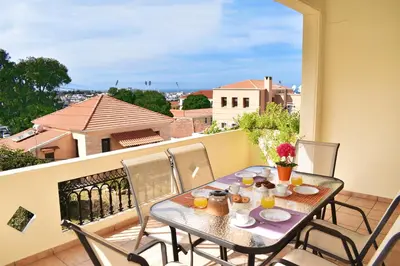 a table and chairs on a balcony with a view at Marelen Apartment Near Chania Center in Chania Town