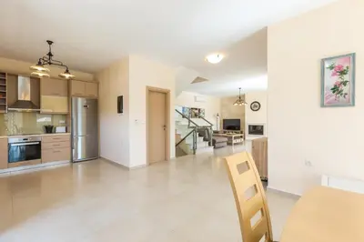 a kitchen and living room with a table and chairs at Rodi Stone Villa in Kalyves