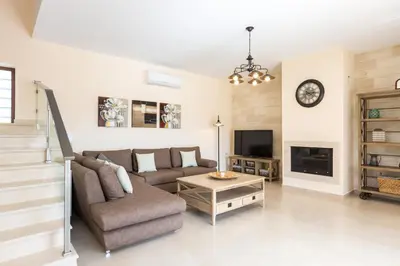 a living room with a couch and a tv at Rodi Stone Villa in Kalyves