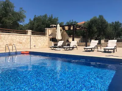 a swimming pool with lounge chairs and a swimming pool at Levanda Luxury Stone Villa in Kalyves