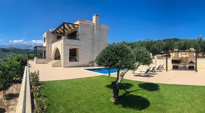 a house with a pool and a tree in the yard at Levanda Luxury Stone Villa in Kalyves