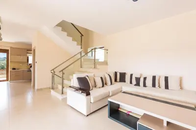 a living room with a white couch and stairs at Levanda Luxury Stone Villa in Kalyves