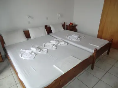 a bed with white sheets and towels on it at Flisvos Rooms in Frangokastello