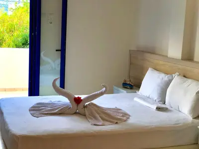 a bedroom with a bed with a stuffed animal on it at Flisvos Rooms in Frangokastello