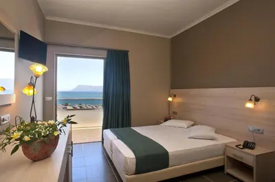 a hotel room with a bed and a view of the ocean at Elena Beach Hotel in Kissamos