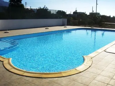 a large swimming pool with blue water at Flisvos Apartments in Frangokastello