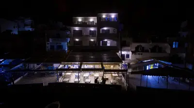 a night view of a building with lights on at Kyma in Loutro