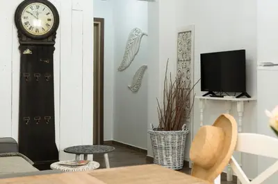 a living room with a clock and a tv at EvaEle Luxury Boutique in Kissamos