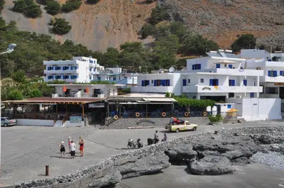 a group of people standing in front of white buildings at Paralia guest house in Agia Roumeli