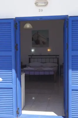 a bedroom with a bed through a blue door at Paralia guest house in Agia Roumeli