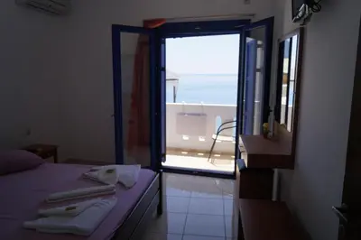 a room with a bed and a door to a balcony at Paralia guest house in Agia Roumeli